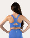 Back view highlighting racerback keyhole and hook-back closure on the blue sports bra
