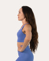 Right side profile of the blue sports bra showing wide straps and supportive band