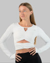 White gym top, ruched long-sleeve crop in three-quarter front view with front cut-out