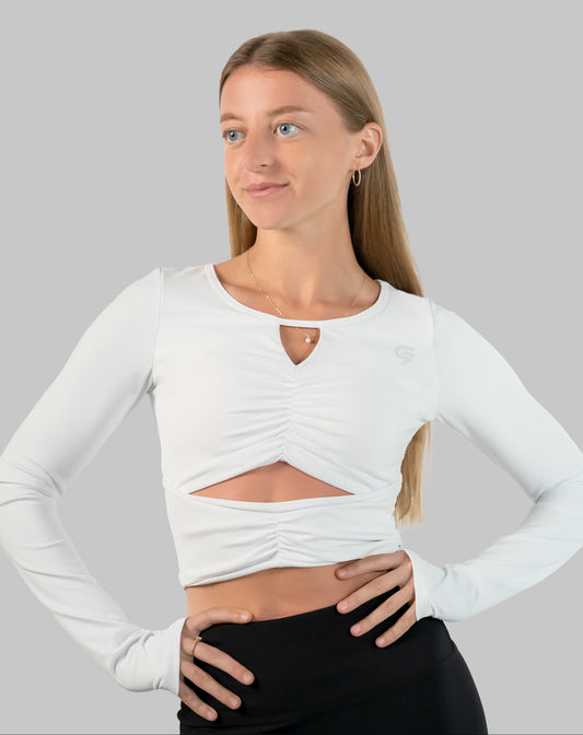 White gym top, ruched long-sleeve crop in three-quarter front view with front cut-out