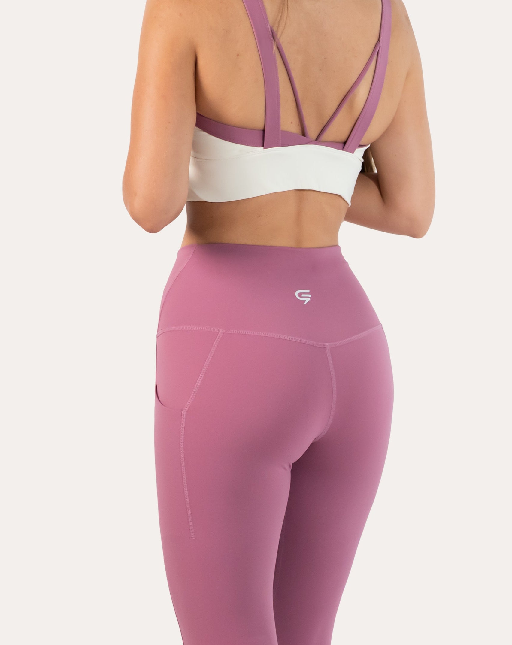 Back three-quarter close-up of white/lilac women’s sports bra showing lilac straps and open back