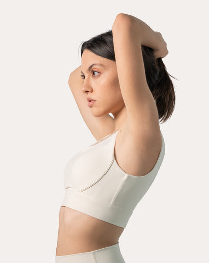 Close-up of cream longline sports bra with supportive structure and clean seams