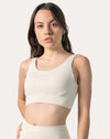 Front close-up of the cream supportive sports bra showing scoop neckline and stabilising underband