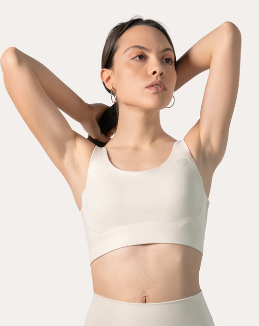 traight-on front, mid-length view of the cream supportive sports bra with wide straps and smooth band
