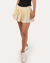 Front close-up of cream tennis skirt showing pleated hem and smooth performance knit