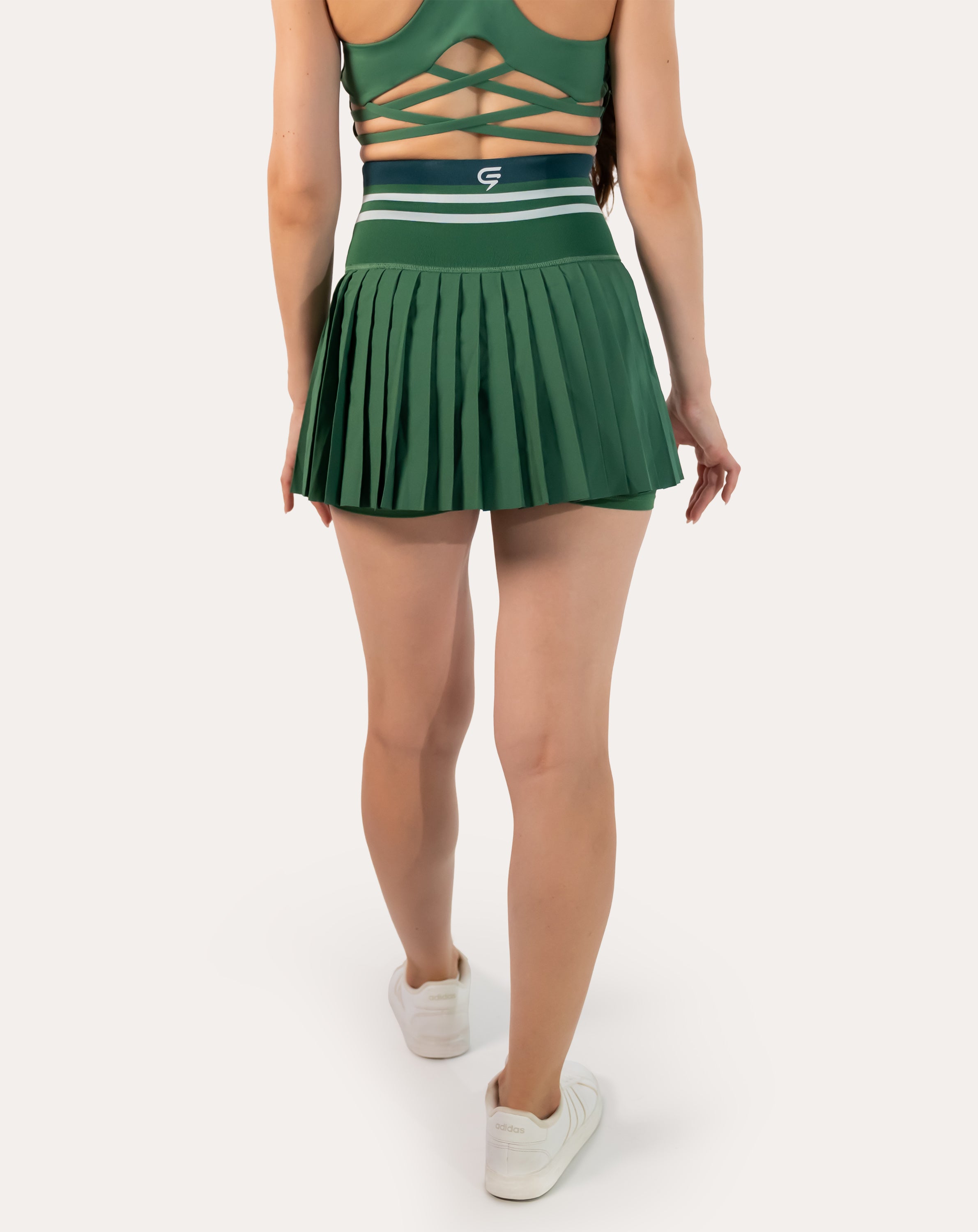 Full-body back view of forest green pleated tennis skirt with striped high-waist band