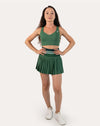 Full-body front view of forest green pleated tennis skirt with high-waist striped band