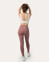 Full-body back view of matching set with rose-clay high-waisted leggings and ivory sports bra; secure stay-put waistband
