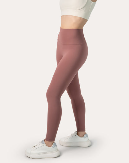 Side profile highlighting sculpting fit and smooth, buttery fabric of rose-pink high-waisted leggings