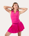 Front view of hot pink gym set with pleated skirt and collared V neck tank.