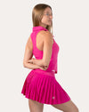 Side view showing the hot pink gym set’s pleated skirt and ribbed collared tank.