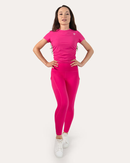 Hot pink running leggings with pockets; front full-length view, hands on hips