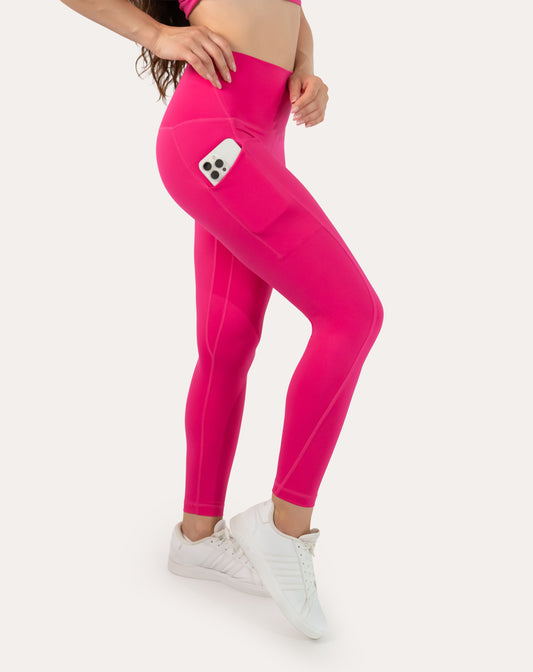 Hot pink running leggings with pockets; high-waisted fit, left three quarter view showing phone pocket