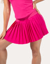 Front three-quarter close-up of hot pink tennis skirt with high-rise striped waistband and micro pleats