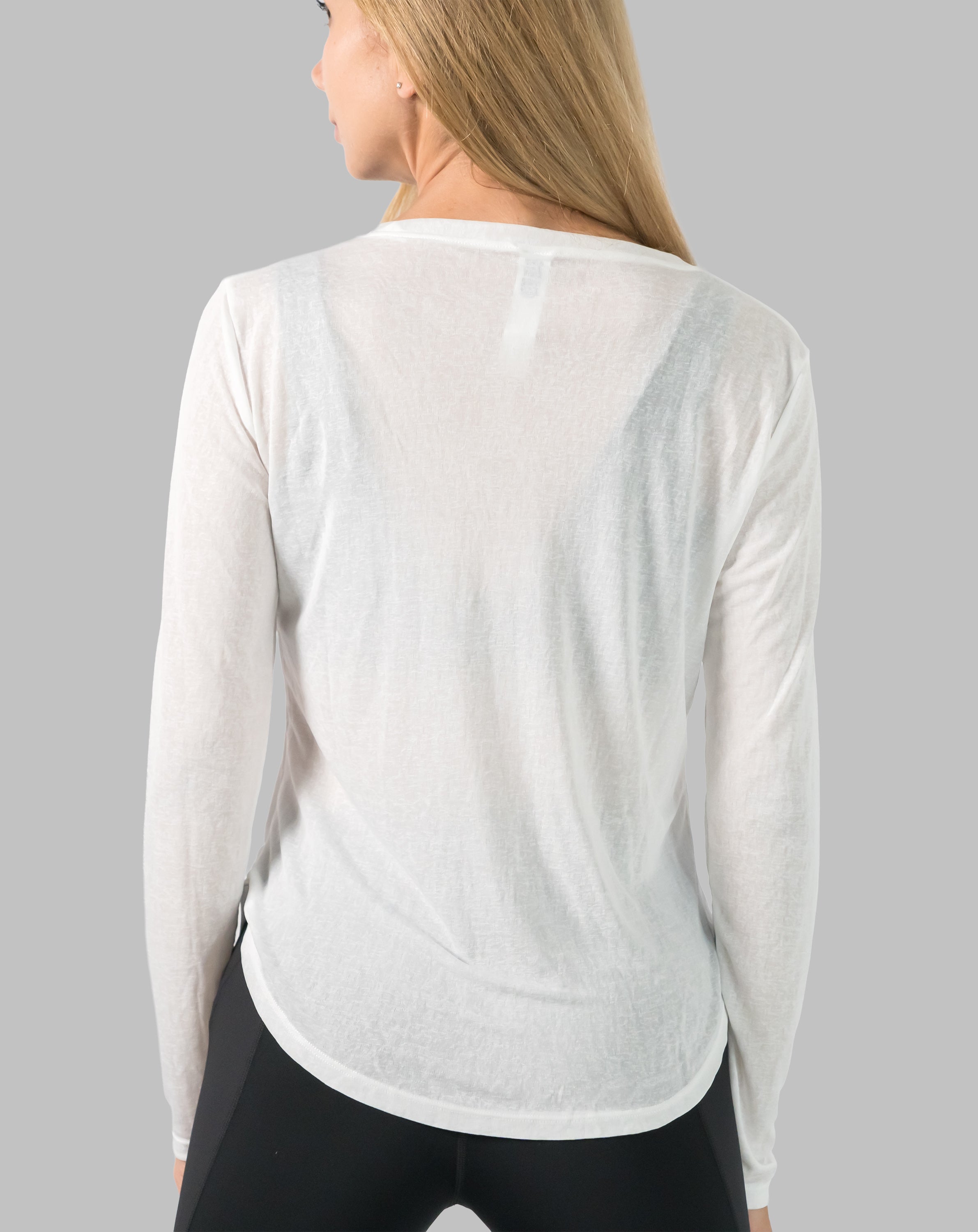 Back close-up of white ladies long sleeve gym top highlighting sheer knit and curved hem