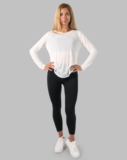 Front full-length, hands on hips; white ladies long sleeve gym top with breathable sheer knit