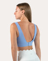Right back three-quarter view of light blue square neck sports bra showing deep V hook-back