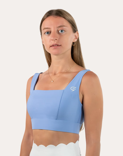 Right front three-quarter view of light blue square neck sports bra with wide straps