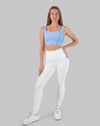 Full-body front view wearing a light blue square neck sports bra with white leggings
