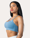 Right front three-quarter view of light blue strappy sports bra with thin straps and shaped cups