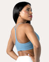 Left side profile of light blue strappy sports bra showing thin straps and smooth underband