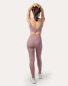 Back view of light pink gym leggings and top set highlighting hook-and-eye clasp back on the bra
