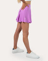 Right side view of lilac tennis skirt with shorts highlighting scalloped hem and flowy mini cut