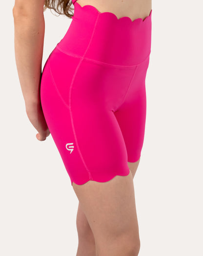 Shorts close-up of neon pink gym set showing high-waist biker shorts side seam and small logo