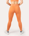 Orange gym leggings with high waisted fit; straight back view