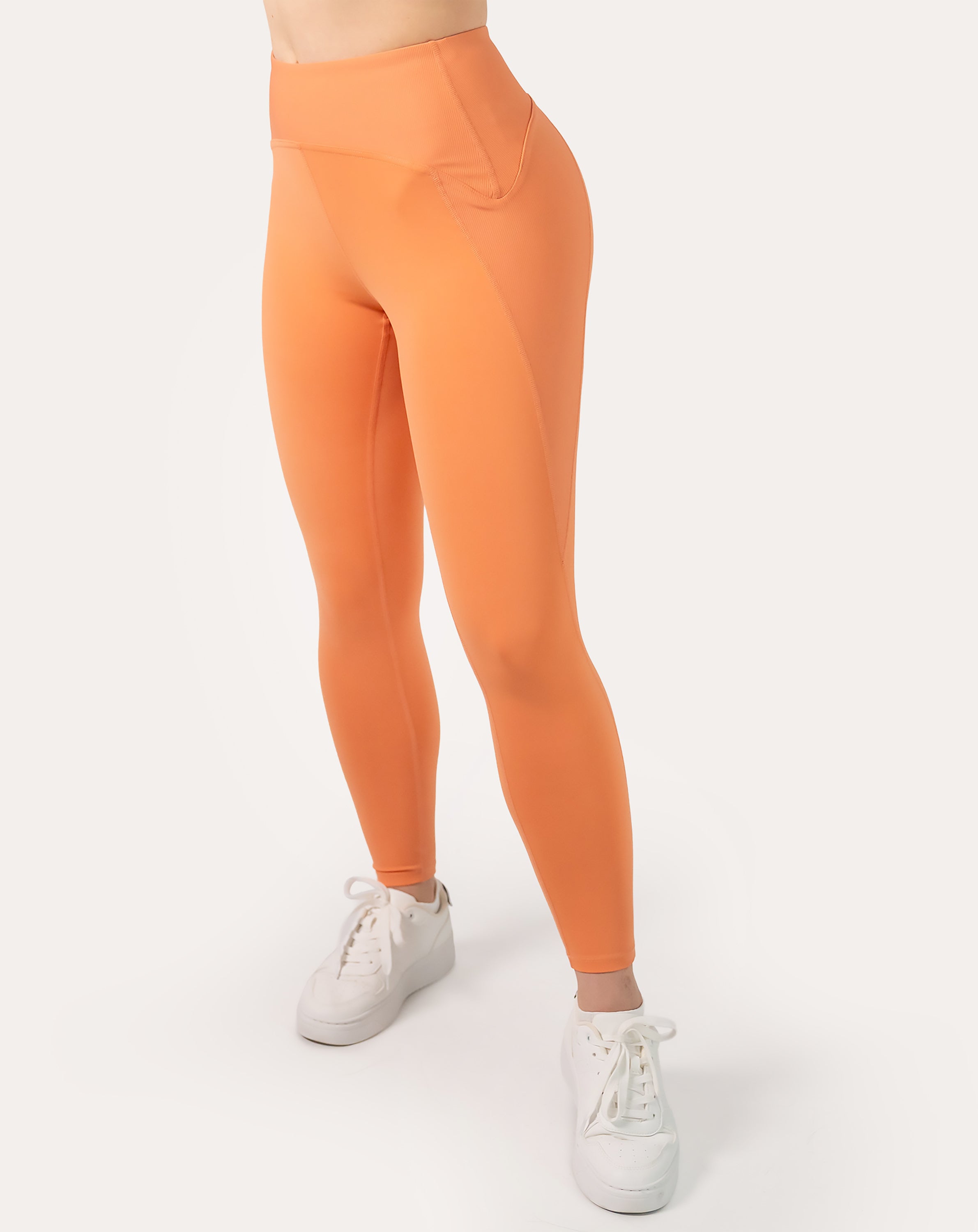 Orange gym leggings with high waisted fit; left three quarter view