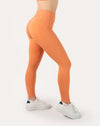 Side detail of orange gym set leggings highlighting high-waist fit and smooth seams