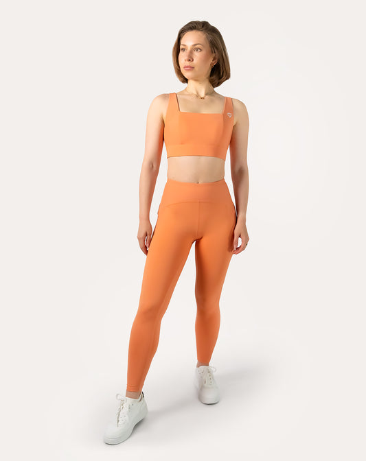 Orange gym set, three-quarter front view with square-neck bra and high-waist leggings