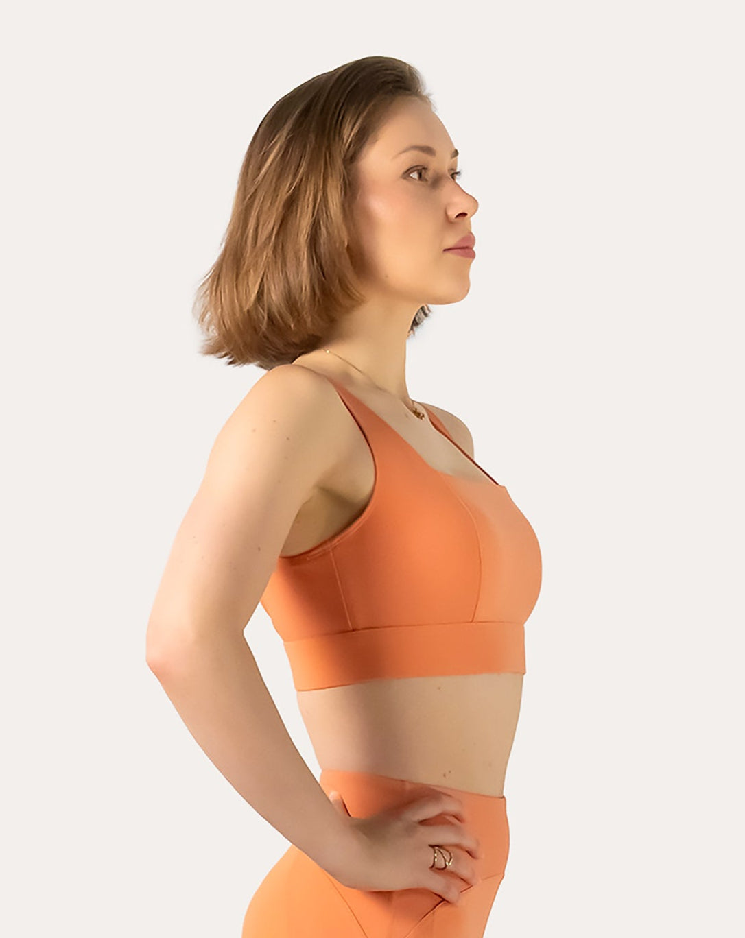 Right front three-quarter view of orange sports bra with square neck