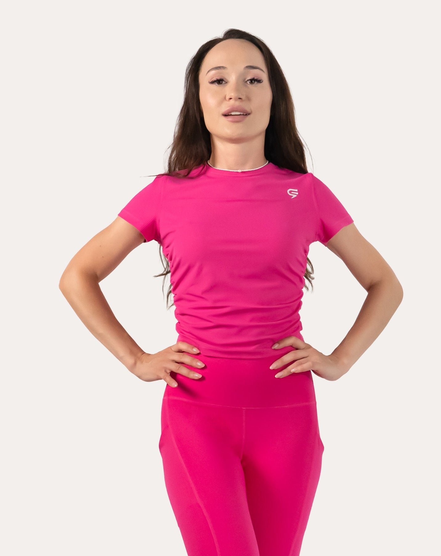 Hot pink women’s gym top, front close-up with short sleeves and ruched side panels