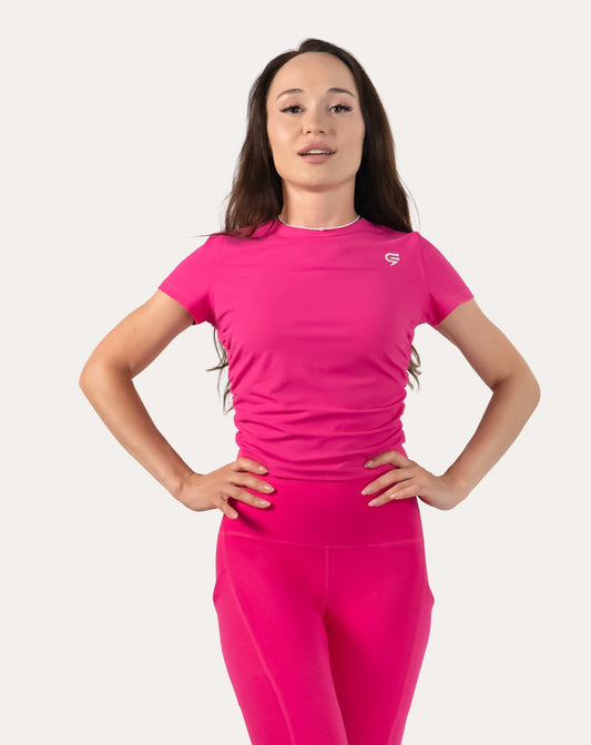 Hot pink women’s gym top, front close-up with short sleeves and ruched side panels