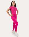 Hot pink women’s gym top in three-quarter front, full length step pose with crew neck