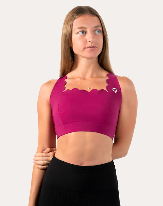 Front three-quarter view of pink sports bra in magenta with scalloped neckline and wide underband