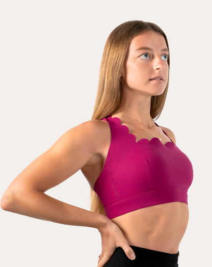 Right front three-quarter view of pink sports bra with scalloped square neckline