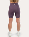 Back view of plum gym shorts with scalloped hem and supportive high waist