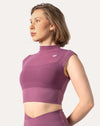Close-up of high-neck longline crop top in plum gym shorts set, mesh panel detail