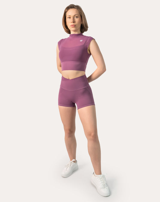 Front view of plum gym shorts set with high-neck longline crop and V-waist shorts