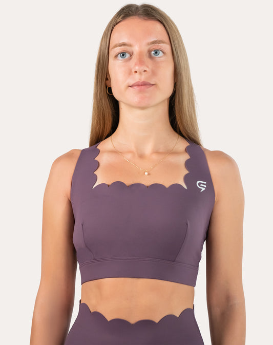 Front view of purple cross back sports bra with scalloped neckline and wide underband