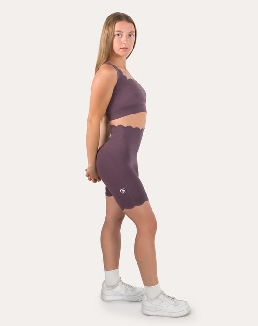 Purple gym set with cross-back bra and high-waist biker shorts, left side full view