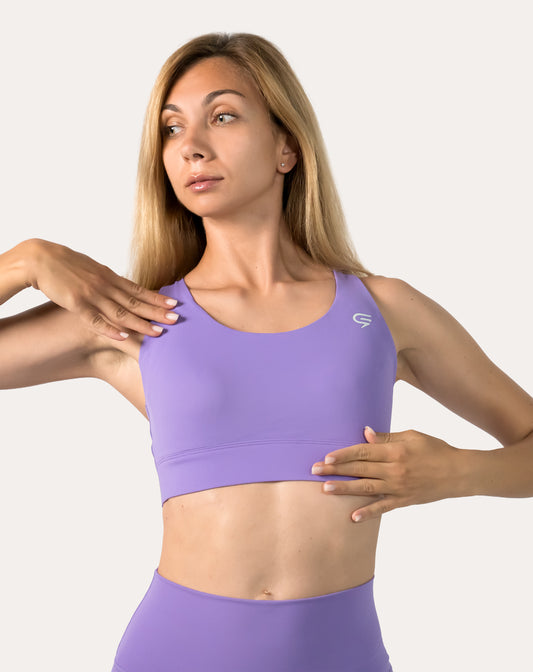 Three-quarter front view of purple sports bra showing scoop front and firm underband