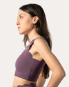 Left side profile of purple sports bra highlighting one-shoulder fit and smooth, quick-dry knit