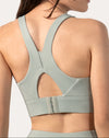 Back three-quarter close-up of the sage green running sports bra showing keyhole and hook-back