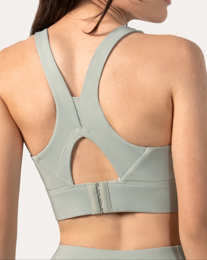 Back three-quarter close-up of the sage green running sports bra showing keyhole and hook-back