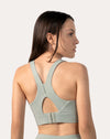 Sage green racerback running sports bra, back close-up showing keyhole and hook-back closure.