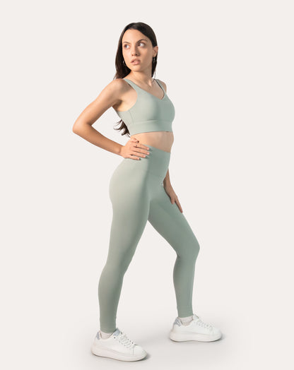 3/4 side view of sage green gym set highlighting high-rise leggings and wide waistband