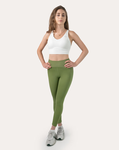 Sage green yoga leggings with V-shaped high waist; front view, hands on hips